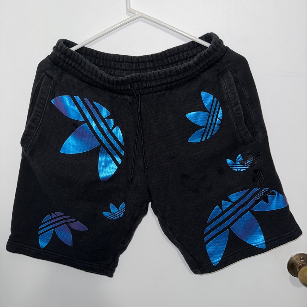 Small adidas sweat shorts with blue/purple logos depending on lighting.